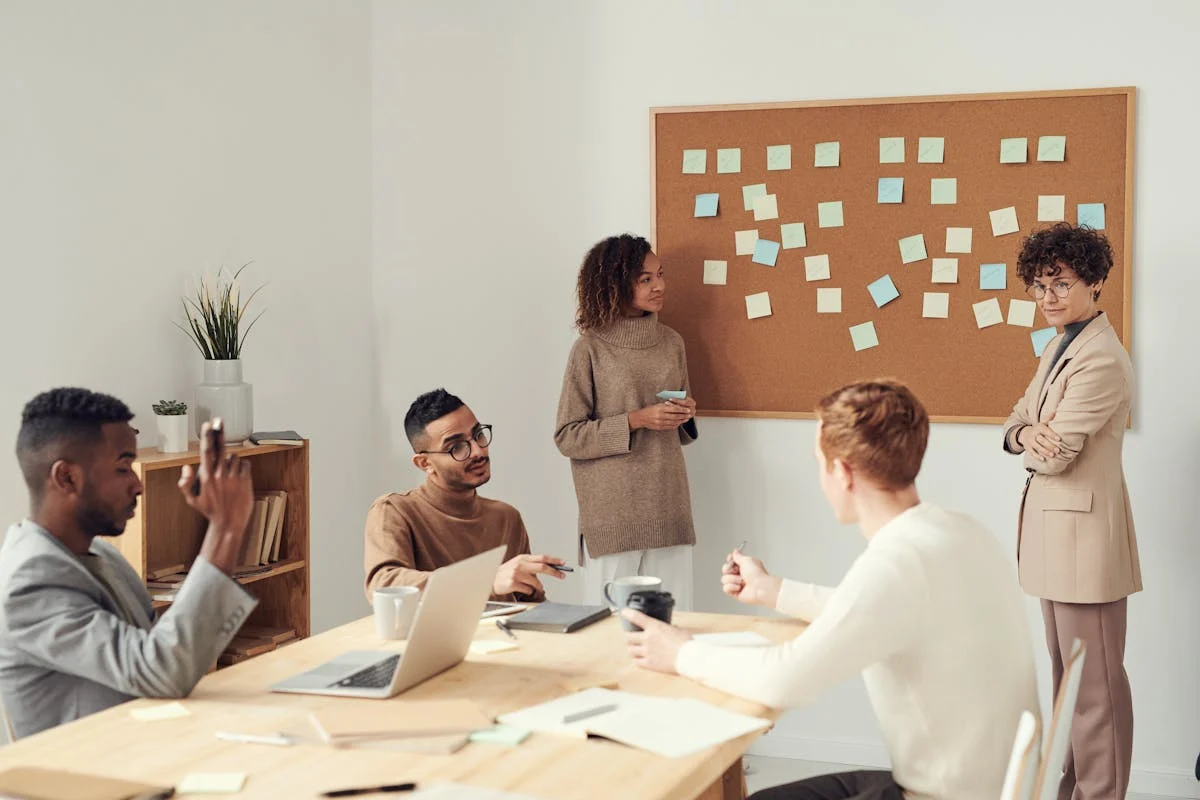 Team of professionals collaborating around laptops in a modern office